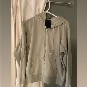brandy melville “christy hoodie”. sage green. never worn. one size! $25 obo